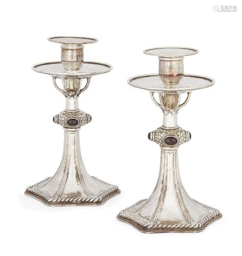A pair of silver plated candlesticks in the manner of Omar Ramsden, the tapering stems to