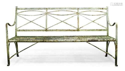 A Regency white painted cast iron garden bench, with shaped openwork back and slat seat, having