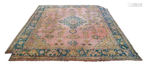 An Ushak carpet, early 20th Century, the medallion in faded brick field with stepped green