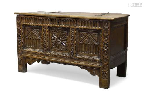 A carved oak coffer, 17th Century and later, the hinged lid enclosing storage compartment, above