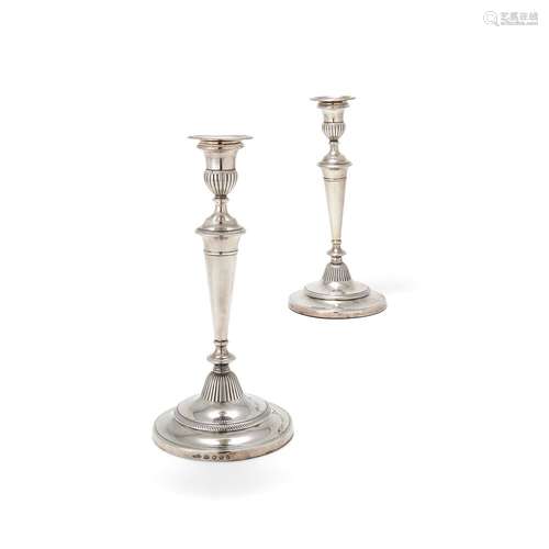 A pair of George III silver circular candlesticks by John Green, Roberts, Mosley & Co.