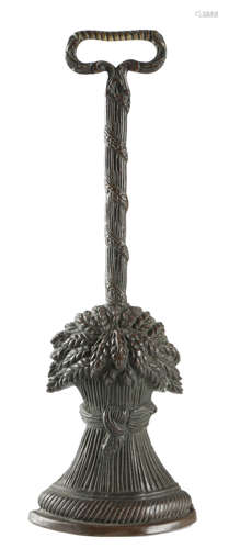 A VICTORIAN PATINATED BRASS DOORSTOP in the form of a wheatsheaf, the wreath handle above a rope