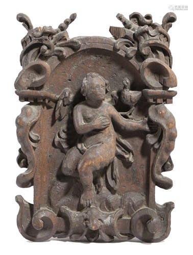 A SMALL CARVED OAK CARTOUCHE PANEL PROBABLY LATE 17TH / EARLY 18TH CENTURY depicting a winged cherub