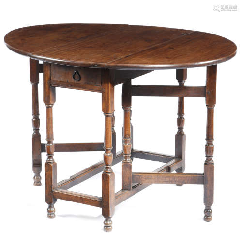 A GATELEG TABLE EARLY 18TH CENTURY AND LATER the later red walnut drop-leaf oval top on an oak