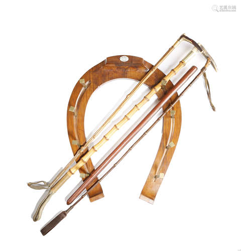 A WALNUT HORSE SHOE SHAPE HANGING WHIP RACK BY MAXWELL FIRST HALF 20TH CENTURY with brass hooks