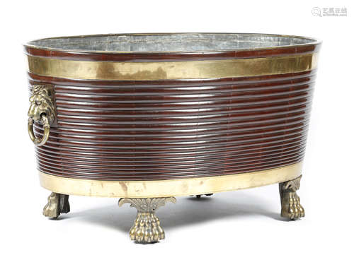 A LARGE MAHOGANY AND BRASS BOUND WINE COOLER IRISH REGENCY STYLE the rim decorated with shells, with