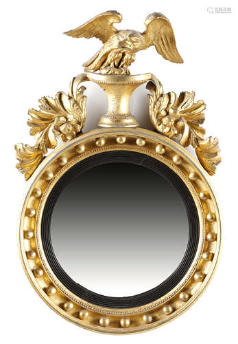 A REGENCY GILTWOOD CONVEX WALL MIRROR EARLY 19TH CENTURY the circular plate within a reeded slip,