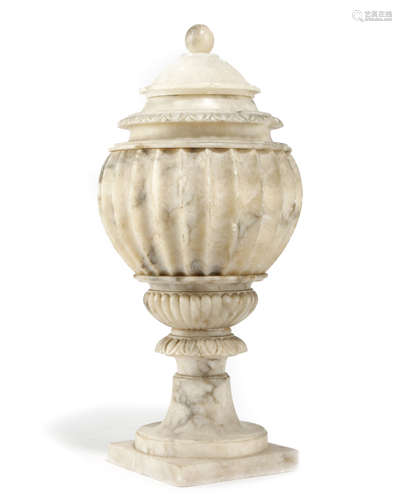 AN ITALIAN CARVED ALABASTER URN AND COVER LATE 19TH CENTURY of fluted baluster shape, with egg and