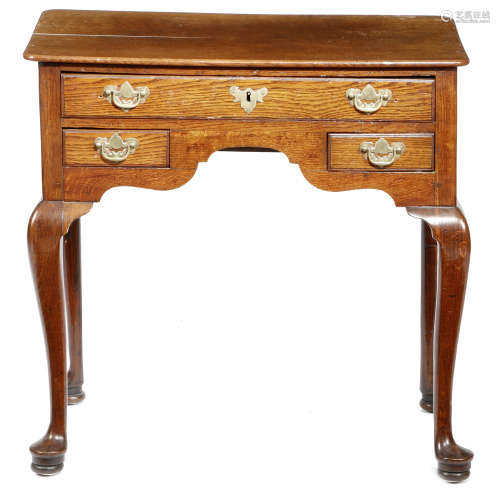A GEORGE II OAK LOWBOY MID-18TH CENTURY the top with rounded corners, above three drawers, on