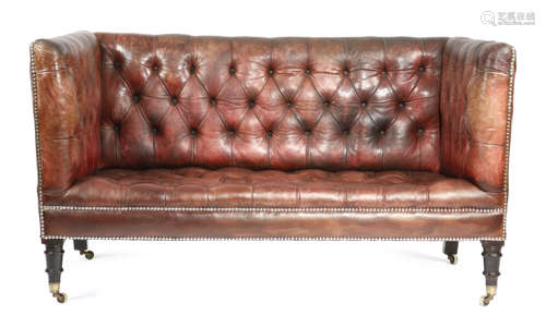 A RED LATHER SOFA LATE 19TH CENTURY AND LATER with a studded and button upholstered back and seat,