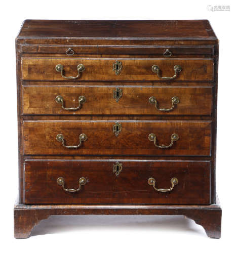 A GEORGE II WALNUT BACHELOR'S CHEST c.1740 the quarter veneered and crossbanded top inlaid with a