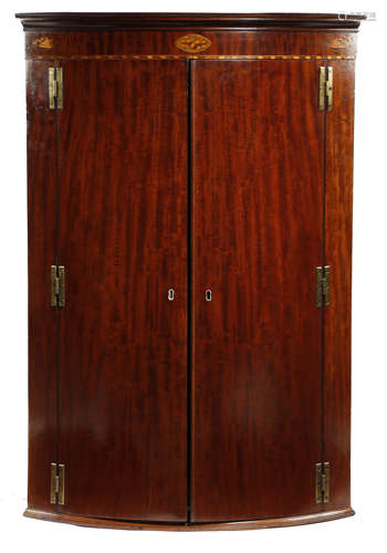 A GEORGE III MAHOGANY BOWFRONT HANGING CORNER CUPBOARD LATE 18TH CENTURY the frieze inlaid with