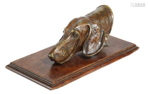 A PATINATED BRONZE HOUND DOG DESK PAPERCLIP LATE 19TH / EARLY 20TH CENTURY mounted on an oak