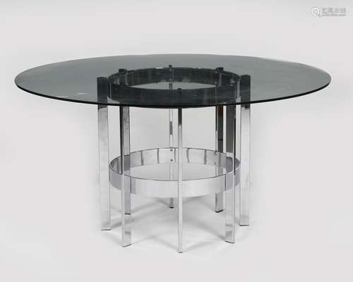 A Merrow Associates chromed metal and glass table, circular glass top resting on chrome metal