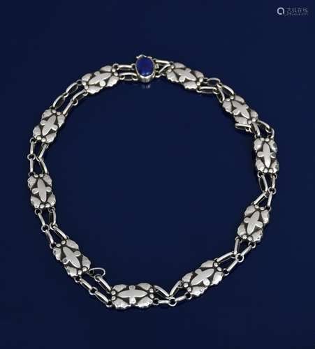 A Georg Jensen silver link necklace with lapis clasp, ten panels cast in low relief with