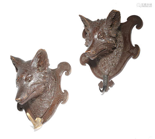 TWO BLACK FOREST CARVED WOOD WALL HANGING COAT RACKS each carved with a fox's head, on a shaped