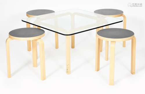 A modern birch ply table and four Artek stacking stools designed by Alvar Aalto, square section