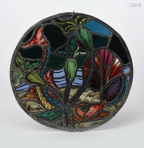 An Arts and Crafts stained glass roundel, decorated with a pike swimming amongst water lily flowers,