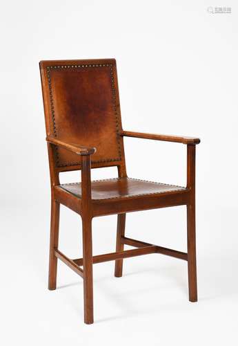 An Arthur Simpson of Kendal walnut armchair, dated 1928, chamfered legs and carved arms, with tan