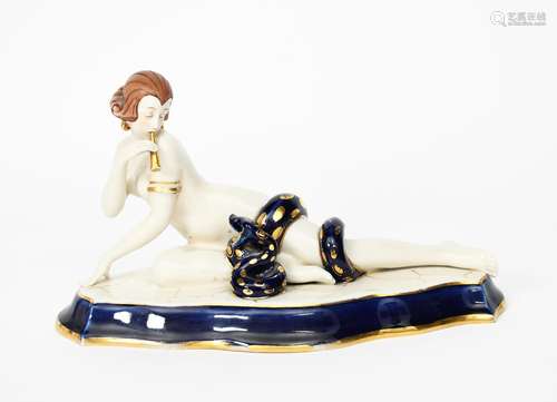 A Royal Dux model of an exotic snake charmer, she modelled naked, lying with a large snake