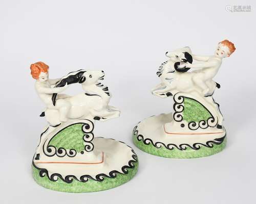 A pair of Art Deco Czechoslovakian pottery centrepiece, each modelled as a child riding a goat,