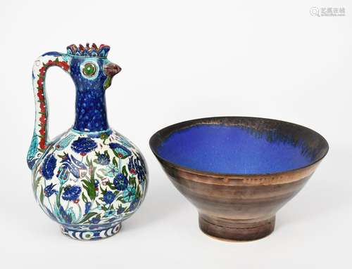 An Iznik style pottery ewer, bellied form with pulled handle, the neck and spout modelled as a