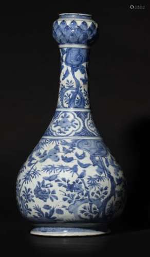 China Exceptional large porcelain bottle vase with long narrow neck ending with a lotus flower shaped bulb, decorated in blue under cover of birds flying among two of the three friends of winter (umbrella pine and bamboo), rocks pierced at the neck with lingzhi mushrooms.  Ming Dynasty, period (1573-1619) H: 54 cm (accidents visible at the pass)