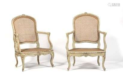 Pair of caned low armchairs in painted beech wood, with rounded backrest, resting on arched legs, decorated with foliage and flowers. (small differences and wear and tear).  Louis XV period.  H : 98 cm, W : 67 cm