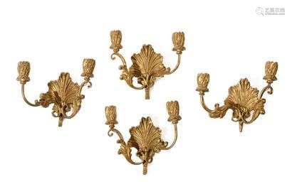 Four two-light wall lights in gilded wood, decorated with palmettes and foliage. Italian style of the 18th century.  H : 23 cm, W : 24 cm