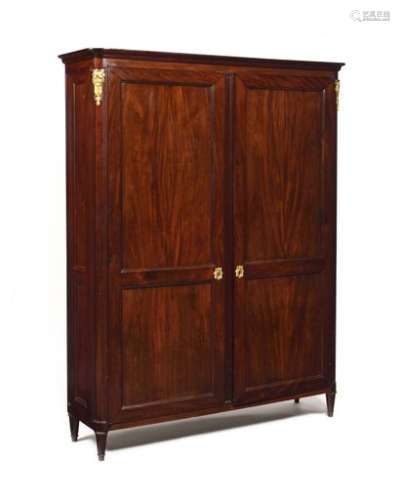 Moulded mahogany cabinet with two doors, the rounded uprights resting on small tapered legs.  Louis XVI style, late 19th century.  H : 199 cm, W : 154 cm, D : 42 cm