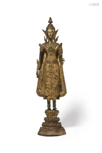 THAILAND A gilded lacquered bronze figure representing a standing Buddha resting on a quadruple base inlaid with mica. End of the 19th century Height : 52.5 cm