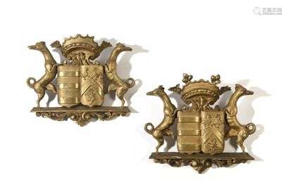 Two gilded wooden decorative elements depicting coats of arms, flanked by dogs and surmounted by a crown. 18th century style (splinters). H : 31 cm, W : 35 cm