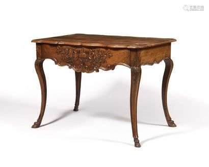 TABLE with an eventful shape made of natural wood molded and carved with volutes, flowers and a vase covered in an entourage of foliage and fruit. The scalloped belt opens to a drawer. It rests on arched feet ending with animal hooves. Regency style with some antique elements.  (restorations, added tray, feet entered) H: 77 - W: 107 - D: 70 cm