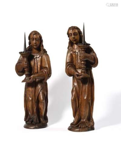 Pair of carved elm carved cerebral angels. Dressed in a long tunic with a scalloped collar, split and leaving one leg uncovered, they each hold a wrought-iron pick and cup. 17th century Height: 66 cm (small vermilions and fillings, missing wings)