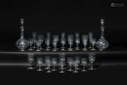 Engraved glass serving part, comprising seven water glasses, eleven red wine glasses, nine white wine glasses, five champagne flutes and two carafes, the base in baluster with a circular base, monogrammed with an L and a double C. 20th century.