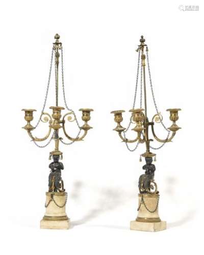 Pair of gilded and patinated bronze child-blower candelabra with three arms of light decorated with foliage and chains supported by Arabesque children resting on cylindrical marble bases (one arm is damaged). Louis XVI style, end of the 19th century. H : 65 cm, W : 24 cm