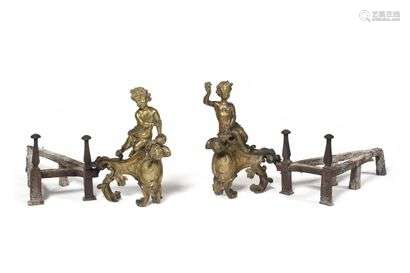 Pair of ormolu bronze andirons decorated with children-bacchus resting on a leafy base with a medallion with profiles, (with their irons). Louis XV period, circa 1725-1730. H: 41.5 cm, W: 30 cm A pair of similar candlesticks are nowadays kept in the Bayerisches Nationalmuseum in Munich (illustrated in H. Ottomeyer and P. Pröschel, Vergoldete Bronzen, Munich, 1986, p. 71).