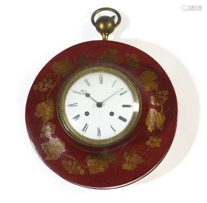 Circular cartel in painted sheet metal with gold decoration of vine branches on a red background, the dial with Roman numerals in a guilloché bezel. Restoration period. D : 32,5 cm