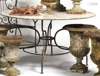 Garden table in painted sheet metal and wrought iron, circular in shape, resting on a quadripod base decorated with scrolls. Beginning of the Xxth century (wear) H : 72 cm , D : 130 cm