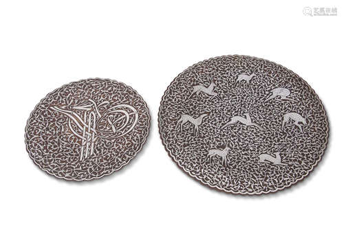 Two Middle Eastern chargers, probably Persian, with silver metal designs on copper, the larger