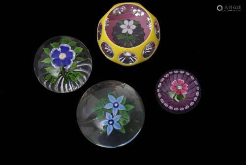 Group of four paperweights including a Baccarat primrose weight with a blue flower with white