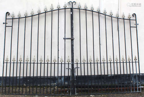 Large pair of wrought iron entrance gates of upright rail form with gilt pike detail and with arched