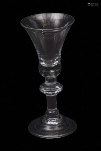 An important early 18th century heavy baluster wine glass with bell bowl with tiered solid base