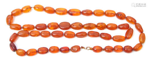 Vintage amber necklace, a single row of graduated olive shaped beads, cognac or honey colour, with
