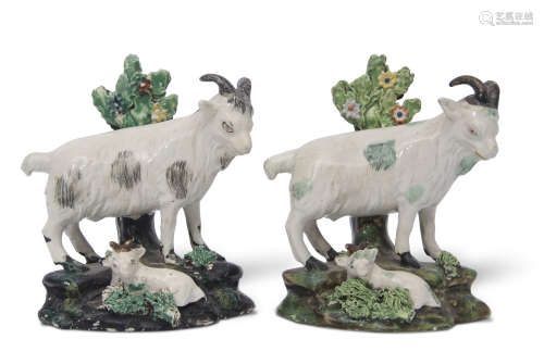 Two mid-19th century Staffordshire models of goats on rocky bases with kids at their feet, (2)