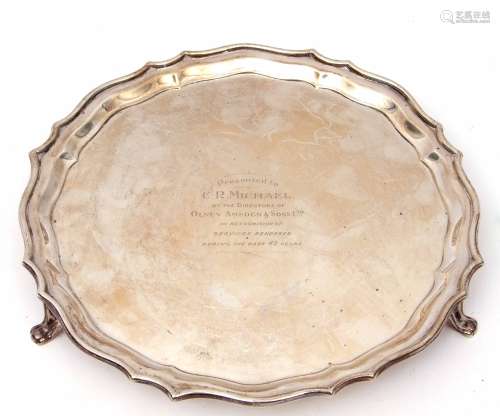 George V salver of shaped circular form with wavy edge, supported on three curved feet, presentation