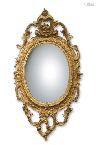19th century gilt and gesso oval mirror with a scrolling open work surround and mounted with a