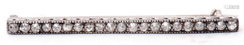 Precious metal diamond set bar brooch, the elongated engraved and pierced bar featuring 21 small old