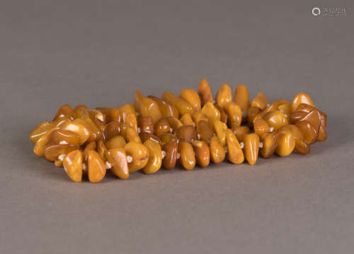 A STRAND OF NATURAL-SHAPED BEADED BEESWAX NECKLACE