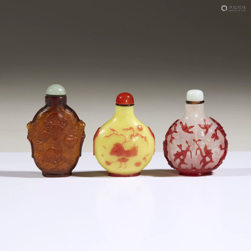 Three carved Chinese glass snuff bottles,